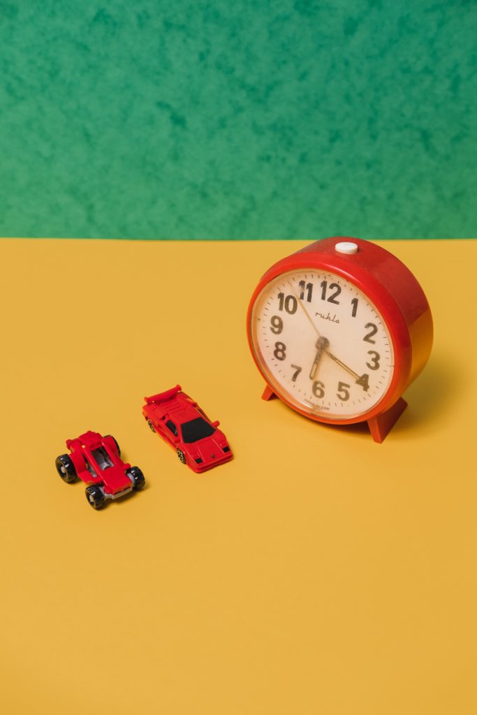 Two red cards sat next to an alarm clock. Parental alienation impacting usefulness of toys.